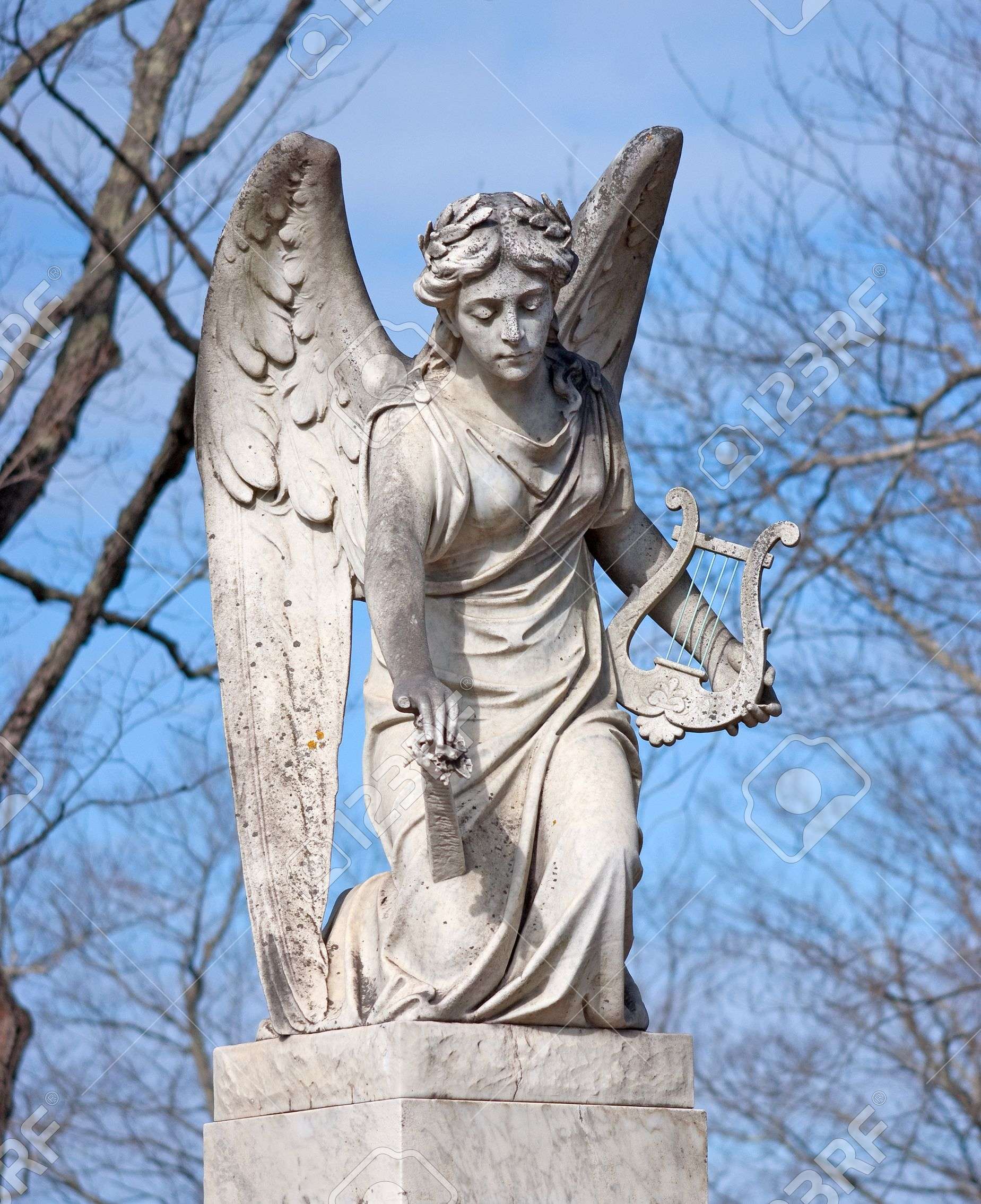 9615874-an-aged-statue-of-an-angel-holding-a-harp-stock-photo-wings